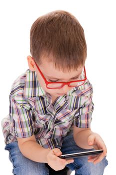 Clever small boy plays with his touch smartphone isolated on white background