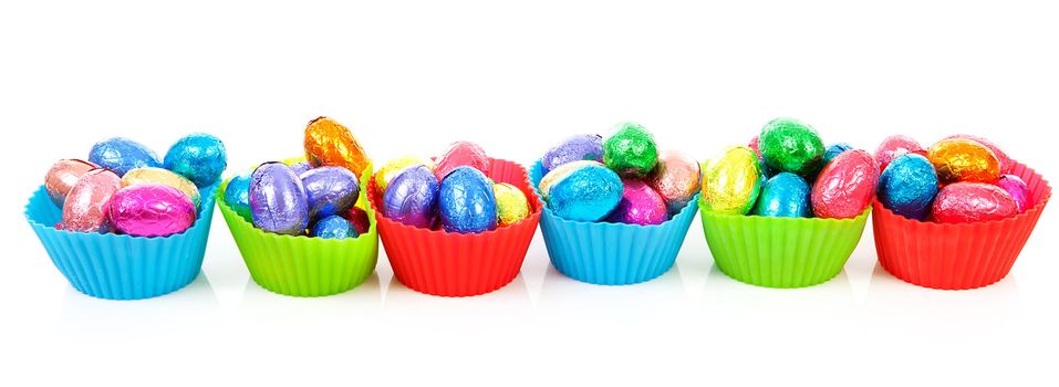 colorful bowls with easter eggs over white background