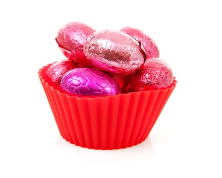red bowl with pink easter eggs over white background