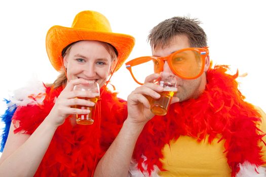 Two Dutch soccer fans in orange outfit cheering for the soccer games with glasses beer, over white background