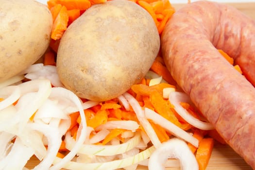 Ingredients for Dutch hutspot stew on wooden cutting board in closeup