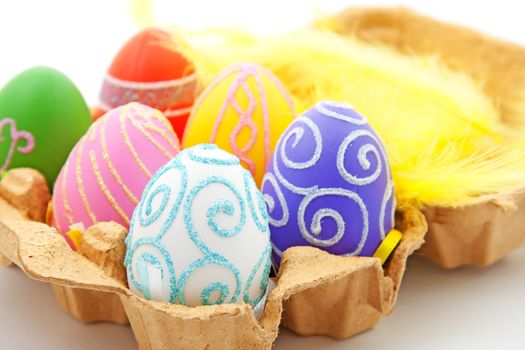 Six colorful easter eggs in box over white background