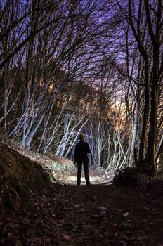 Girl lost in dark forest at night.