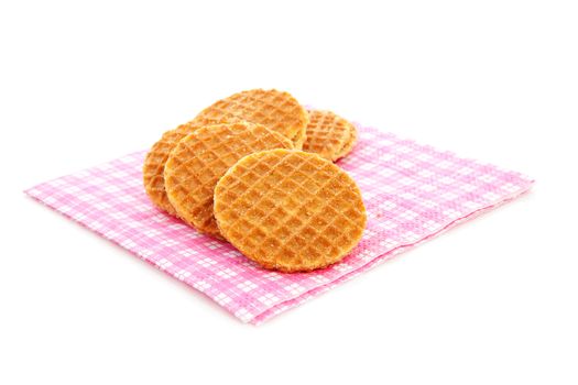 Pile of typical Dutch stroopwafels ( with syrup) on napkin over white background