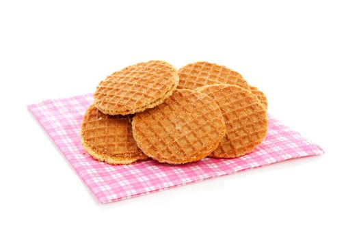 Pile of typical Dutch stroopwafels ( with syrup) on napkin over white background