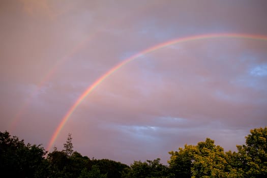 colorful rainbow in cloudy sky