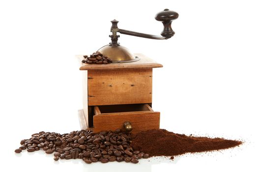 Old wooden coffee grinder and beans over white background