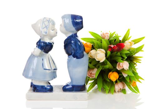 Typical Dutch souvenir in Delft blue and plastic tulips  over white background