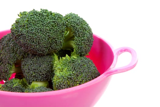 pink colander with broccoli vegetable over white background