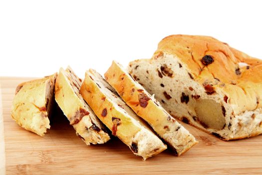 slices of raising bread on wooden cutting board over white background