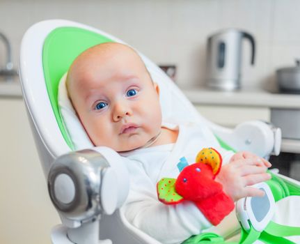 Closeup portrait of sweetest baby girl playing with a colorful mobile toy