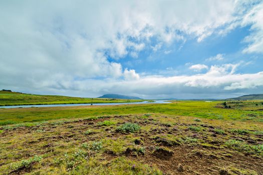 Glacier great fast blue river with green banks in Iceland