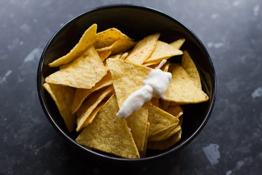 bowl of tortilla chips on a black kitchen counter