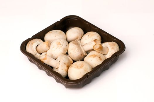 isolated mushrooms in a brown packaging tray
