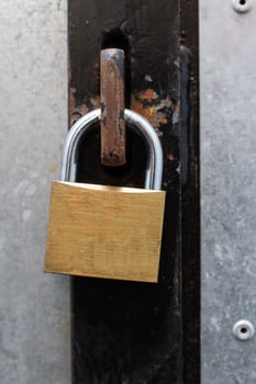 a brass padlock securing an iron door together