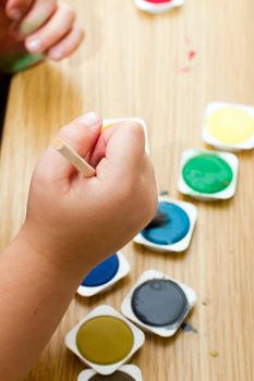 young boy painting a picture with a paintbrush