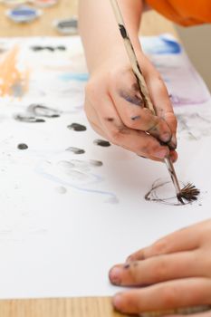 young boy painting a picture with a paintbrush