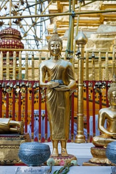 gold buddha images in front of golden temple being reconstructed