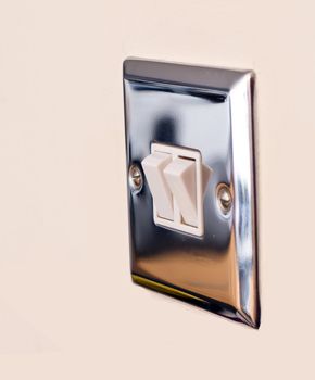 Chrome light switch on a magnolia wall