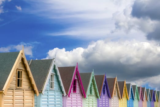 row of beach huts blue sky