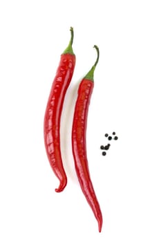 two chili peppers and pepper peas on a white background