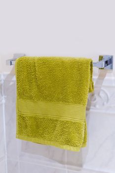 Green towel hanging on a chrome rack
