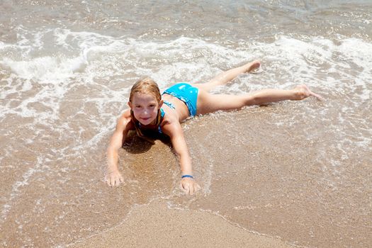 child on the beach in waves and water