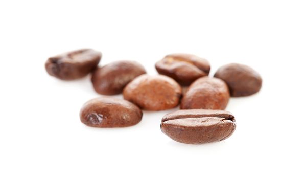 Macro of fresh roasted coffee beans over white background
