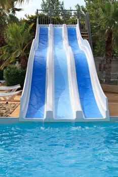 swimming pool with slides on holiday in tropical environment