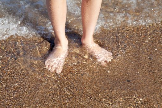 Closeup of children feet in the ocean