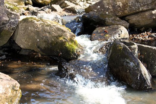 The pure, mountain stream flows among the big stones