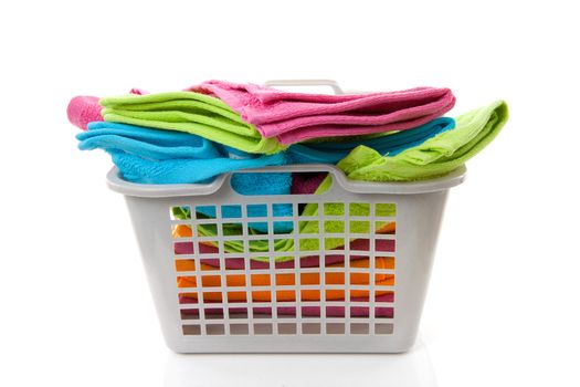 Laundry basket filled with colorful towels over white background