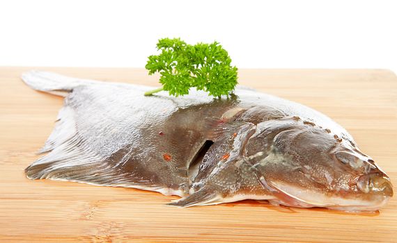 raw plaice fish on wooden cutting board