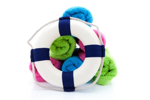 summer gear; colorful towels and life buoy over white background