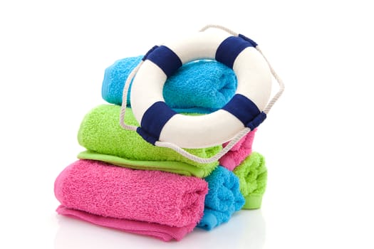 summer gear; colorful towels and life buoy over white background