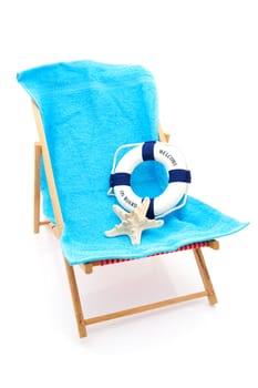 beach chair with blue towel and life buoy over white background