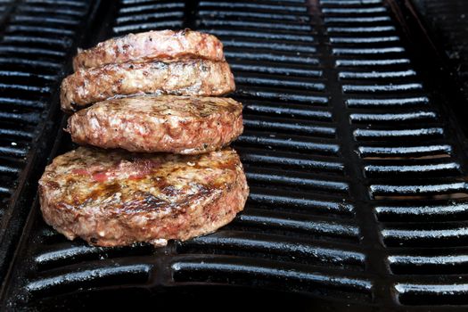 Beef quarterpounder burgers cooking on the gas barbecue