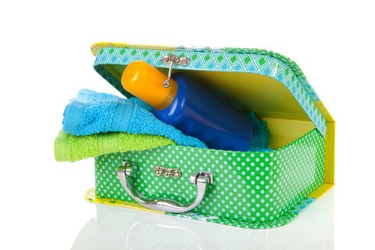 Suitcase, sunscreen and towels over white background