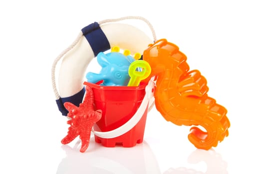 Beach toys and life buoy over white background