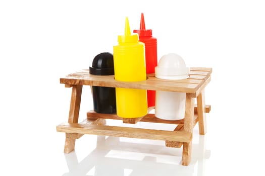 picnic table with salt, pepper and sauce bottles over white background