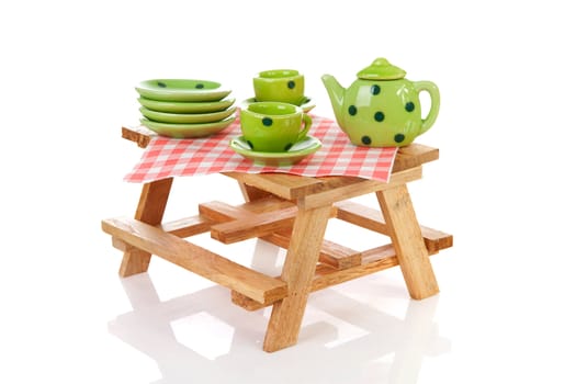 picnic table with green dotted tablewear over white background