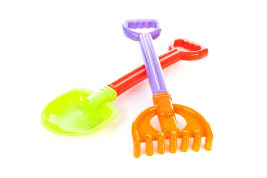 Colorful beach toys; shovel and rake, over white background