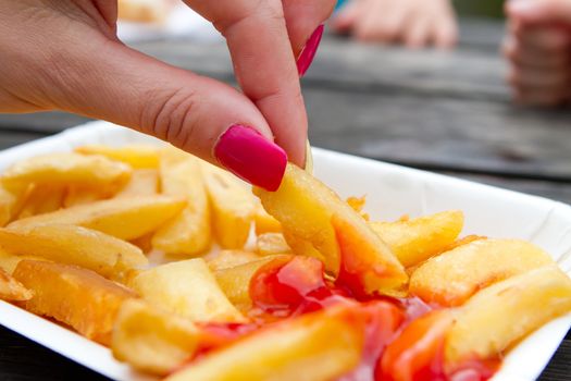 woman with pink nails eating chips