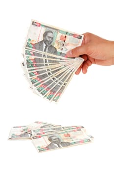 Hand holding Kenyan currency over white background