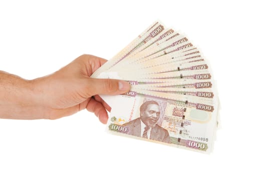 Hand holding Kenyan currency over white background