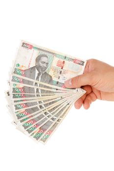 Hand holding Kenyan currency over white background