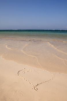 heart drawn into sand on beautiful tropical beach