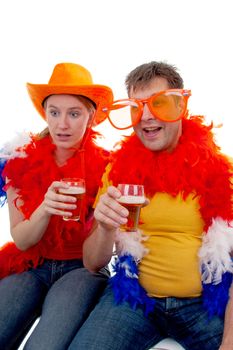 Two Dutch soccer fans in orange outfit with glasses of beer, over white background
