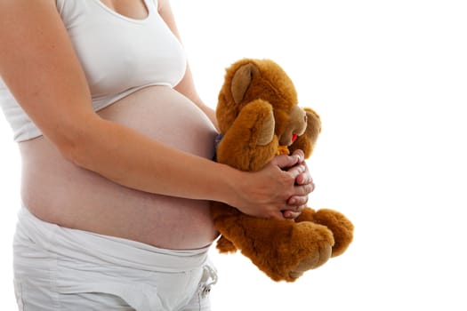 pregnant belly with Teddy bear over white background