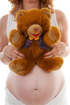 pregnant belly with Teddy bear over white background